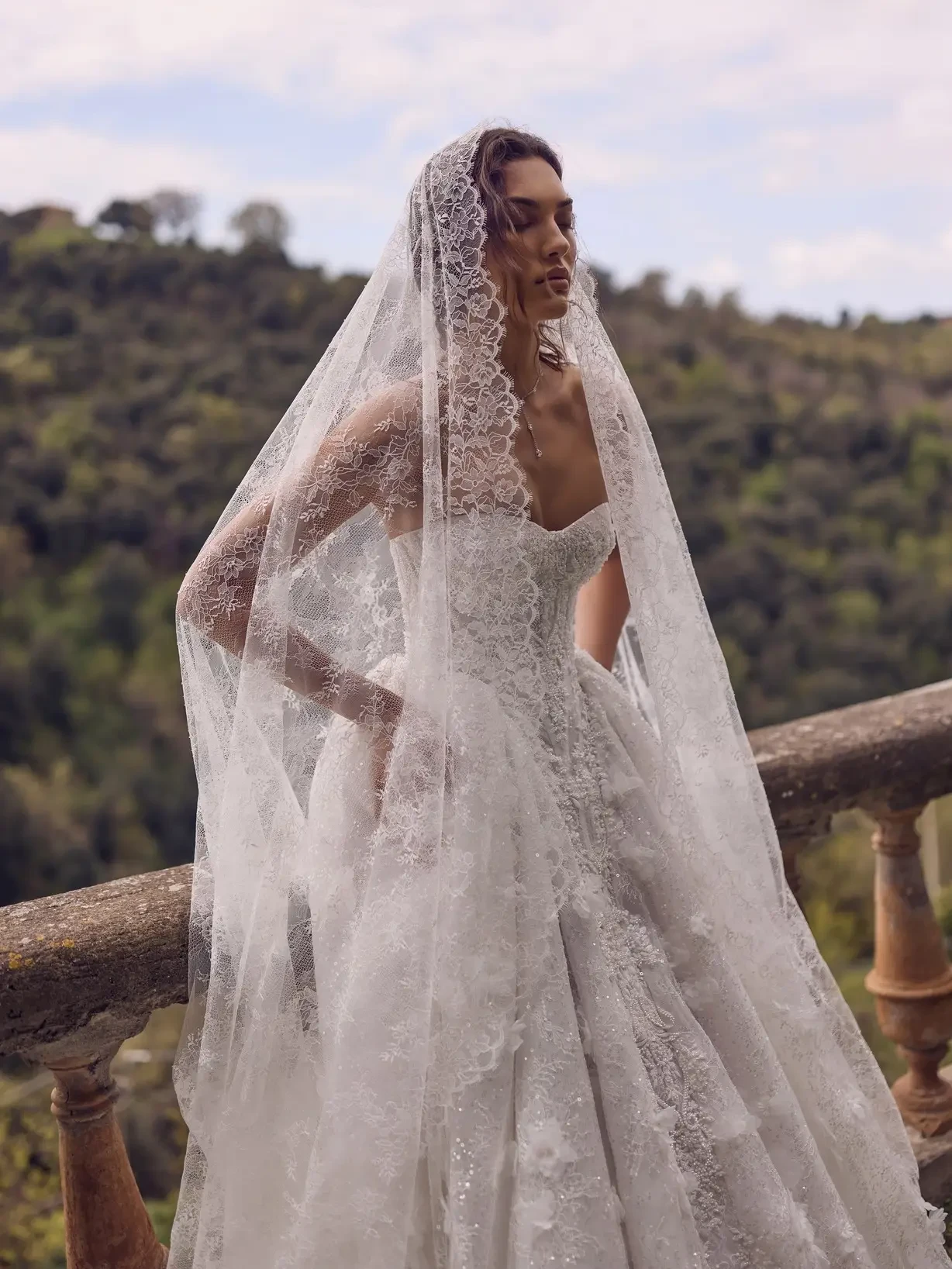 Bride wearing a modern lace wedding dress with sheer lace sleeves